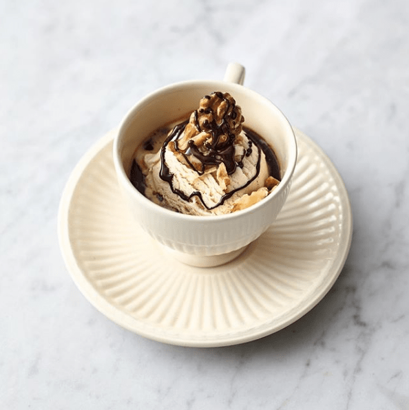 Taza de helado caliente con chocolate y nueces